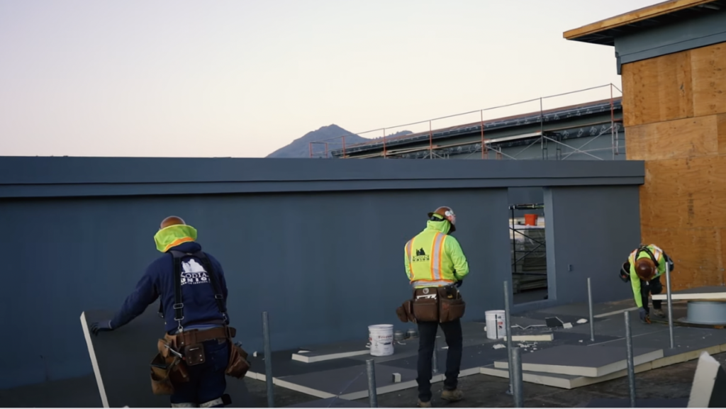Team of Kodiak commercial roofers working on installing a roof. 